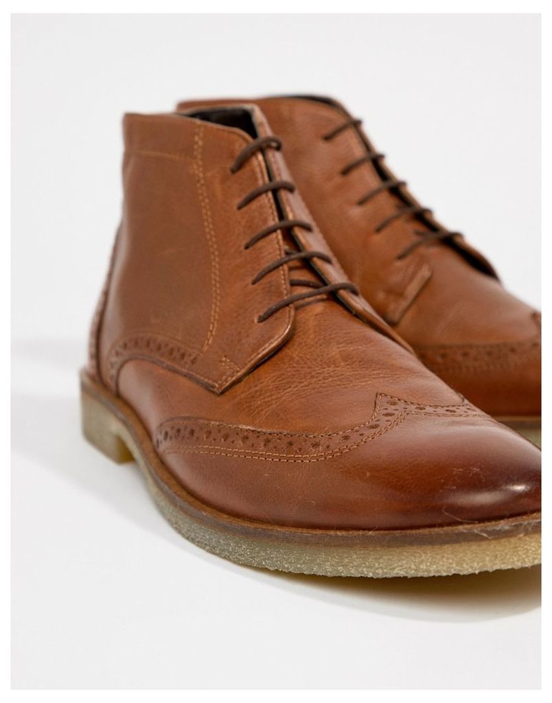 brogue boots in tan leather with natural sole